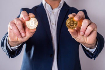Golden Bitcoin in a man hand, Digitall symbol of a new virtual currency
