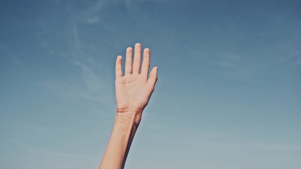 People rasing hands on blue sky background. Voting, democracy or volunteering concept