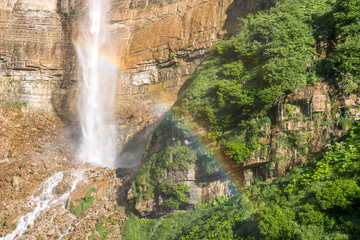 Fototapeta na wymiar Rainbow on Kinchkha waterfall near Okatse canyon, Imereti, Georgia