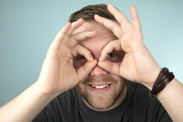 Young man making a spectacles gesture