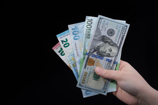 Hand holding American dollar  isolated on black background