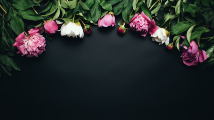 Beautiful table top view of pink and white peonies on the black background. Flat lay of peony flowers on the table. Your text. Empty space. Floral concept © Christina Moroz