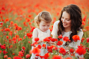 mother and daughter playing in flower field