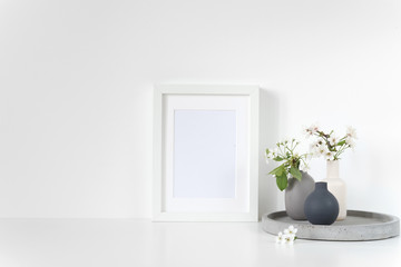 White frame mockup with spring cherry bouquet on concrete tray. Mock up for your photo, design or text.