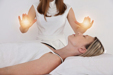 Woman having reiki healing treatment , alternative medicine concept.
