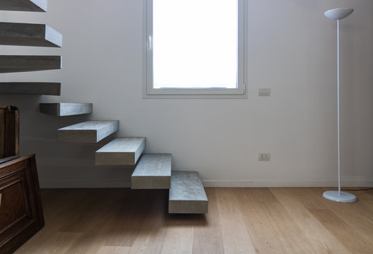 Empty modern home interiors, with a concrete steps minimalist staircase. White window in the middle.