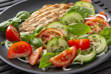 Vegetable salad and grilled chicken on a black background. Healthy food. Diet.