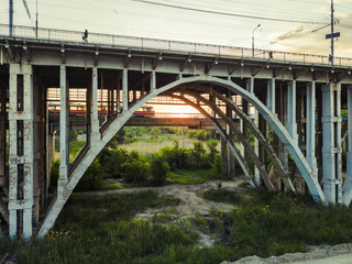 Obraz premium urban dirty dusty old bridge with the tram on the rails under it