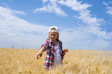 The happy girl shows on what that into the sky .  Portrait of the happy beautiful young woman . in the field of wheat . 
