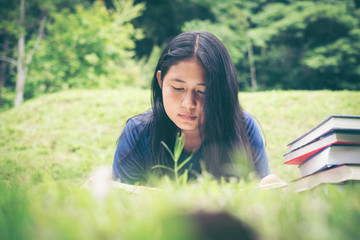 Outdoor portrait of a cute young girl reading a book - Asia people