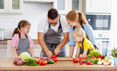 happy family with children preparing vegetable salad .