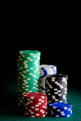 casino chips of different colors on green felt table