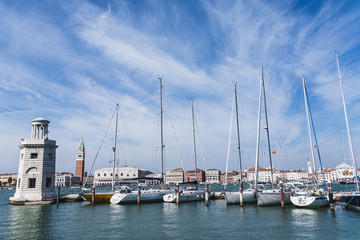 Fototapeta na wymiar Sailboats by San Giorgio Maggiore Lighthouse
