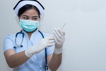 Nurse holding medical syringe with needle in ampule getting ready for patient injection.