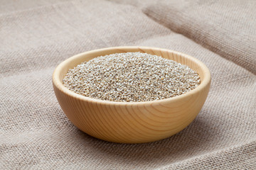 White quinoa seeds in the wooden bowl