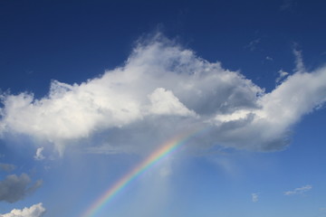 Rainbow through cloud with blue sky