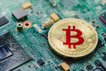 Golden Bitcoin virtual currency on a circuit board background