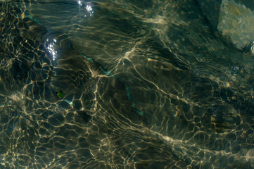pebble stones on the sea beach, the rolling waves of the sea with foam