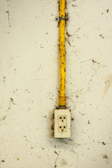 old electric outlet plug installed with the conduit at the concrete wall, It has many cobwebs
