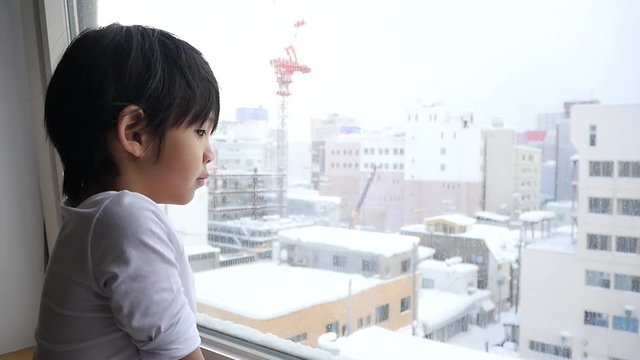 Asian child looking at the window slow motion 
