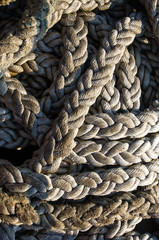 Old braided rope on the wooden deck of a sea boat