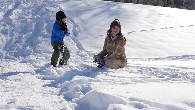 Asian mother and her son playing snow together in the park , sapporo japan slow motion 