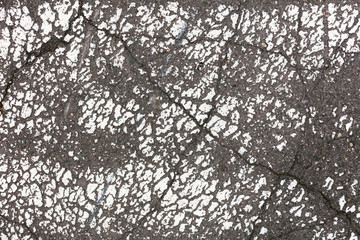 old white road marking on grey asphalt surface. macro shot. abstract background