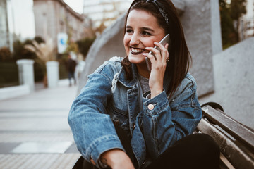 Urban cool young woman speaking on the phone in the city.