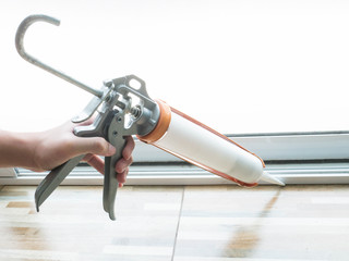 Construction workers installing windows and using silicon