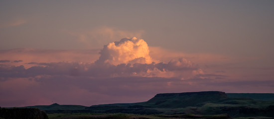 Fototapeta premium Puffy cloud over canyons near Palouse Falls at sunset