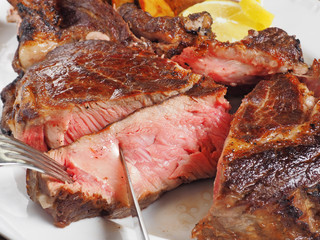 Knife cut slice of grilled meat on plate