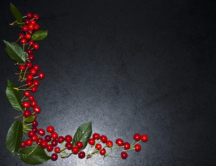 A lot of red cherries on a black background, a composition of berries