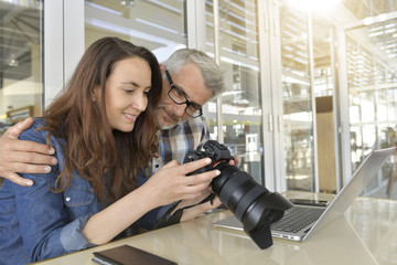 Couple in bar looking at photo shots on camera