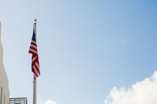 American flag waving against blue sky.