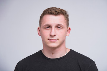 Fototapeta premium portrait of a cute young guy on a white background in different poses with different emotions.