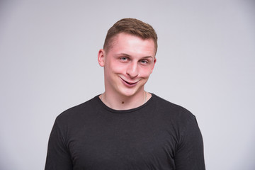 Obraz premium portrait of a cute young guy on a white background in different poses with different emotions.