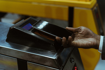 Cropped view of male hand with smartphone paying public transport fare