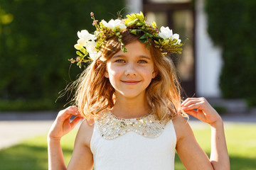 Beautiful girl with a wreath of fresh flowers