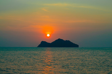 Naklejka na ściany i meble Sunset Behind an Island in the Sea at Koh Phaghan in Suratthani Thailand.