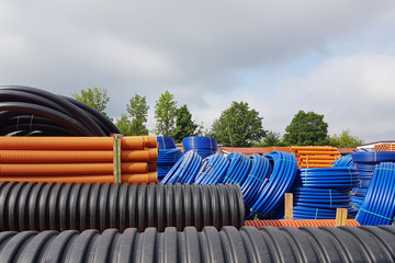 A warehouse of plastic pipes for various purposes, diameter and color under the open sky....