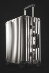 Suitcase or traveling luggage bag isolated on black background