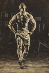 Fototapeta na wymiar Vintage photos of strong bodybuilder athletic man pumping up muscles workout bodybuilding concept background