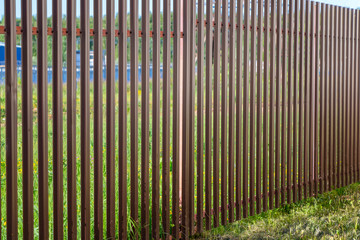 Metal fence of metal profiles brown