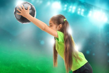 little girl in sports uniform plays soccer