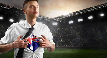 Australia soccer or football supporter showing flag under his business shirt on stadium.