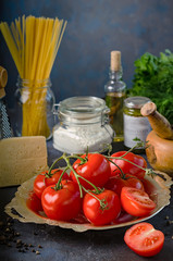 Products for cooking - pasta, tomatoes, garlic, olive oil and spices.