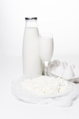 close-up shot of milk, cottage cheese and eggs in carton on white surface
