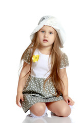 Little girl is sitting on the floor.