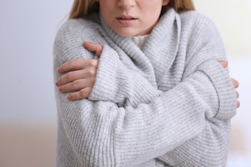 Woman suffering from cold on blurred background