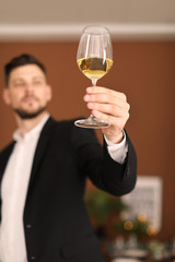 Young man with glass of wine indoors